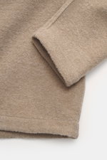Nahaufnahme des Stone Island Overshirt beige aus Bouclé-Mix von Wolle und Microfaser, ungefüttert, Detail der Ärmelnaht, weiche, griffige Oberfläche sichtbar.