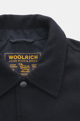 Close-up front view of Woolrich Down jacket navy melange showing wool and microfiber fabric, light down filling, slim fit, snap button placket, adjustable collar with button tab, slanted welt pockets, cuff sleeves with cuffs, adjustable waist width, quilt