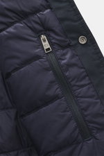 Close-up inside view of the Woolrich Down jacket navy melange showing quilted, smooth lining fabric, zippered inside pocket, snap button placket, and microfiber with wool exterior. Features include light down filling, slim fit, adjustable collar with butt