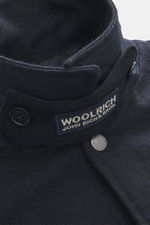 Close-up front angle of Woolrich Down jacket navy melange showing adjustable collar with button tab, snap button placket, wool and microfiber fabric, light down filling, slanted welt pockets, cuff sleeves with cuffs, adjustable waist width, quilted smooth