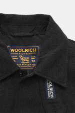 Close-up front view of the Woolrich Down jacket black melange collar showing wool and microfiber fabric, light down filling, snap button placket, adjustable collar with button tab, slanted welt pockets, cuff sleeves with cuffs, adjustable waist width, qui