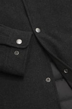 Close-up detail of the Woolrich Down jacket black melange from above, showing wool and microfiber fabric, snap button placket, adjustable collar with button tab, cuff sleeves with cuffs, slanted welt pockets, light down filling, slim fit, adjustable waist