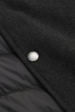 Close-up from above of the Woolrich Down jacket black melange showing wool and microfiber fabric, snap button placket, and smooth quilted lining.