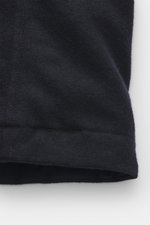 Nahaufnahme der Woolrich Daunenjacke 'Alaskan' navy meliert, Slim Fit mit Wolle und Microfaser, leichter Daunenfüllung, Druckknopfleiste, variablem Kragen, Brust- und Leistentaschen, Manschettenärmeln und gestepptem Futter, seitliche Perspektive.