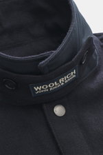 Nahaufnahme aus schräger Perspektive der Woolrich Daunenjacke 'Alaskan' navy meliert mit variablen Kragen, Druckknopfleiste, Wolle und Microfaser.