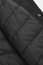 Close-up interior view of the Woolrich Down jacket 'Alaskan' black melange showing quilted smooth lining fabric, light down filling, wool and microfiber trim, snap button placket, adjustable collar with button tab, patch chest pockets, slanted welt pocket