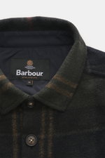 Barbour Overshirt 'Woodlane' khaki/navy kariert close-up from above showing collar, buttons, and Barbour label, soft brushed wool-mix.

<p>Kanadisches Holzfällerkaro, neu gedacht: Der gebürstete Woll-Mix fühlt sich weich an, hält angenehm warm und bleib