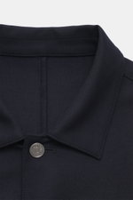 Nahaufnahme des Ace Denim Overshirt navy von oben, elastische Schurwolle, Slim Fit, Umlegekragen, Fünf-Knopf-Leiste, aufgesetzte Brusttaschen, paspelierte Fronttaschen, Ärmel mit Manschette, leicht griffige Haptik.