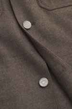 Nahaufnahme des Ace Denim Overshirt graubraun meliert aus elastischer Schurwolle mit Slim Fit, Umlegekragen, Fünf-Knopf-Leiste, aufgesetzten Brusttaschen, paspelierten Fronttaschen und Manschetten, perspektivisch von schräg oben fotografiert.