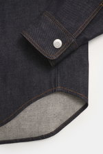 Close-up front-side view of Ami Paris Denim overshirt navy cuff, showing pure cotton fabric, textured feel, heavy quality, oversized fit, snap button placket, turn-down collar, patch chest pocket with logo stitching, cuffed sleeve ends, and unlined interi