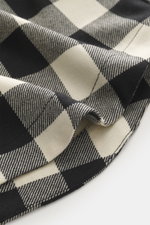 Close-up front view of Ami Paris Overshirt black/cream checkered fabric showing pure new wool texture and detailed stitch.

Description:  
<p>Casual through the transitional season: The overshirt by AMI PARIS impresses with a loose fit made of pure wool i