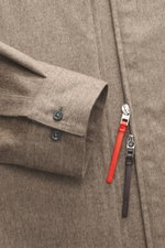 Close-up front view of Jacquemus Overshirt taupe meliert, showing reine Schurwolle, weicher Griff, Oversized Fit, Umlegekragen, Zwei-Wege-Reißverschluss, Logo-Stitching, dekorative Leder-Zipperanhänger, klassische Sportmanschette, gerader Saumverlauf.