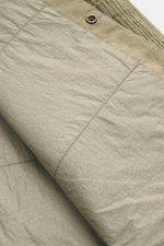 Close-up image of the C.P. Company Cord overshirt sand showing the soft, velvety pure cotton corduroy fabric, snap button detail, and stitching from a diagonal top-down perspective.