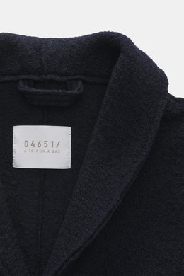 Nahaufnahme von Kragen und Label des navyfarbenen 04651/ A trip in a bag Woll-Overshirt 'Boiled' navy, Bouclé-Strick aus reiner Schurwolle, gewalkte Qualität, weicher Griff, Raw-Edge-Finish, Slim Fit, Vier-Knopf-Leiste, Schalkragen, aufgesetzte Brusttasch