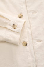Nahaufnahme des weißen 04651/ A trip in a bag Cord-Overshirt navy, fotografiert von oben, zeigt Cord aus Baumwolle, leicht elastische Qualität, soften Griff, Slim Fit, Umlegekragen, Fünf-Knopf-Leiste, Taschen in der Seitennaht und klassische Sportmanschet