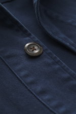 Nahaufnahme aus schräger Perspektive des navy Overshirts 04651/ A trip in a bag Overshirt 'Workwear Jacket' navy mit reiner Baumwolle, Slim Fit, Umlegekragen, Fünf-Knopf-Leiste, aufgesetzten Brusttaschen, leicht griffiger Haptik und Unconstructed Design.