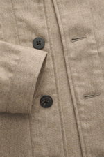 Nahaufnahme aus schräger Draufsicht des 04651/ A trip in a bag Overshirt beige meliert mit Vier-Knopf-Leiste, Schalkragen, Slim Fit, Woll-Microfaser-Mix, leicht griffiger Haptik, Taschen in der Seitennaht und einer Innentasche.