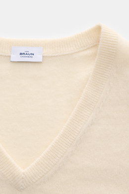 Close-up front view of the von Braun Cashmere V-Neck Pullover creme showing the soft, fine knit and V-neckline with a label inside the collar. 

<p>Geschmeidiges Basic für die kalte Jahreszeit: Der VON BRAUN V-Neck Pullover – gefertigt aus reinem Cashme