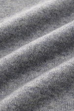 Nahaufnahme des von Braun Cashmere V-Neck Pullovers grau meliert, feines Strickbild, weicher Griff, elastische Rippbündchen sichtbar.