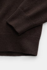 Nahaufnahme des Malo Cashmere V-Neck Pullovers dunkelbraun, seitlich fotografiert, zeigt weichen, mittelfeinen Strick mit breiten Rippbündchen.