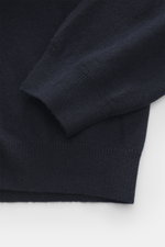 Close-up front view of the Aida Barni Cashmere V-neck jumper navy, showing fine knit pattern, ribbed cuffs, and soft pure cashmere fabric. Luxury-class essential: The Italian label AIDA BARNI processes premium cashmere in this timeless V-neck sweater with