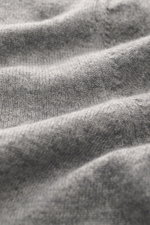 Nahaufnahme des feinen Strickbilds und weichen Griffs vom Aida Barni Cashmere V-Neck Pullover grau meliert, Perspektive frontal auf das Material.