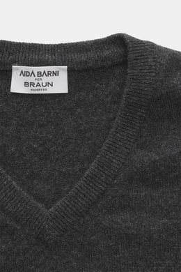 Close-up front view of Aida Barni Cashmere V-neck jumper dark grey melange showing fine knit, ribbed cuffs, and label for luxury-class pure cashmere.

<p>Luxury-class essential: The Italian label AIDA BARNI processes premium cashmere in this timeless V-ne