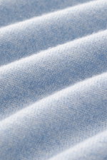 Nahaufnahme des Aida Barni Cashmere V-Neck Pullovers hellblau meliert, zeigt feines Strickbild, weichen Griff und Rippbündchen aus reiner Cashmere-Qualität.