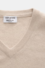 Close-up top view of Aida Barni Cashmere V-neck jumper sand melange, showing fine knit, ribbed cuffs, and label.

<p>Luxury-class essential: The Italian label AIDA BARNI processes premium cashmere in this timeless V-neck sweater with a regular fit.</p>
<u