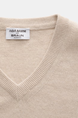 Close-up top view of Aida Barni Cashmere V-neck jumper sand melange, showing fine knit, ribbed cuffs, and label.

<p>Luxury-class essential: The Italian label AIDA BARNI processes premium cashmere in this timeless V-neck sweater with a regular fit.</p>
<u