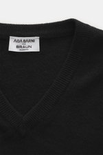 Nahaufnahme des schwarzen Aida Barni Cashmere V-Neck Pullovers aus feinem Strick, V-Ausschnitt und Rippbündchen, von oben fotografiert.