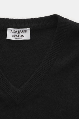 Nahaufnahme des schwarzen Aida Barni Cashmere V-Neck Pullovers aus feinem Strick, V-Ausschnitt und Rippbündchen, von oben fotografiert.