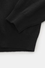 Nahaufnahme des Aida Barni Cashmere V-Neck Pullovers schwarz, zeigt feines Strickbild, Rippbündchen, weichen Griff, Regular Fit, V-Ausschnitt, italienisches Luxus-Cashmere.