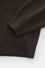 Close-up of the sleeve and hem of the Aida Barni Cashmere V-neck jumper dark brown, showing fine knit and ribbed cuffs from a top-down perspective.