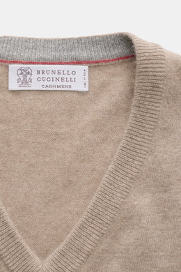 Brunello Cucinelli Cashmere V-Neck Pullover beige, nah aufgenommen von oben, feines Strickbild, schmale Kontrastkanten, weicher Griff, Regular Fit.