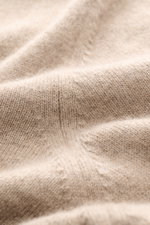 Nahaufnahme des feinen Strickbilds und der weichen Struktur des beige Brunello Cucinelli Cashmere V-Neck Pullovers mit schmalen Kontrastkanten.