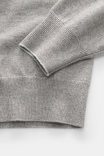 Nahaufnahme des Ärmels und Saums vom Brunello Cucinelli Cashmere V-Neck Pullover taupe meliert, feines Strickbild, schmale Kanten.