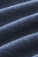 Nahaufnahme des feinen Strickbildes des graublau melierten Brunello Cucinelli Cashmere V-Neck Pullovers, Perspektive von oben, zeigt weichen Griff und hochwertige Struktur.