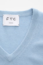 Nahaufnahme des FTC Cashmere V-Neck Pullover hellblau meliert mit V-Ausschnitt, feinem Strickbild und Fair-Trade-Cashmere, frontal fotografiert.