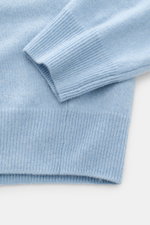 Nahaufnahme des FTC Cashmere V-Neck Pullover hellblau meliert, Perspektive auf Ärmel und Rippbündchen, Slim Fit, feines Strickbild, weicher Fair-Trade-Cashmere.