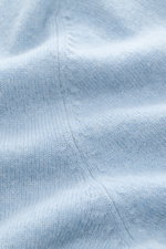 Nahaufnahme des hellblau melierten FTC Cashmere V-Neck Pullovers, fotografiert von oben, zeigt feines Strickbild und weichen Griff.