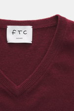 Nahaufnahme von oben auf den bordeauxfarbenen FTC Cashmere V-Neck Pullover mit V-Ausschnitt, feinem Strickbild und Rippbündchen, Slim Fit, aus Fair-Trade-Cashmere.