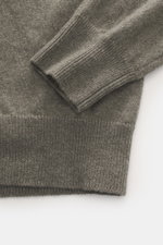 Nahaufnahme des FTC Cashmere V-Neck Pullover graugrün meliert, fotografiert von oben, zeigt feines Strickbild, Slim Fit, V-Ausschnitt, weichen Griff und Rippbündchen aus reinem Fair-Trade-Cashmere.