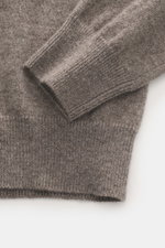 Nahaufnahme des FTC Cashmere V-Neck Pullover taupe meliert, fotografiert von schräg oben, zeigt feines Strickbild, Slim Fit und komfortable Rippbündchen aus reiner Fair-Trade-Cashmere mit sehr weichem Griff.