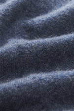 Nahaufnahme des graublau melierten FTC Cashmere V-Neck Pullovers aus Fair-Trade-Cashmere, zeigt weichen Griff, feines Strickbild.