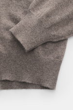 Nahaufnahme des BRAUN Hamburg Cashmere V-Neck Pullover taupe meliert, von oben fotografiert, zeigt reinen Cashmere, sehr weichen Griff, feines Strickbild, Slim Fit, V-Ausschnitt, flexible Rippbündchen, Made in Italy.