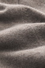 Nahaufnahme des feinen Strickbilds eines taupe melierten BRAUN Hamburg Cashmere V-Neck Pullovers, reiner Cashmere, sehr weicher Griff, Slim Fit, V-Ausschnitt, flexible Rippbündchen, Made in Italy.
