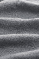 Nahaufnahme des feinen Strickbilds des graumelierten B.F. Knitwear Merino V-Neck Pullovers aus 100% Merinowolle, weich und mit Rippbündchen.