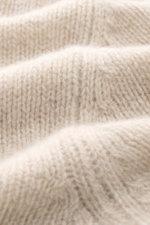 Nahaufnahme des feinen Strickbildes in Mouline-Optik des beige melierten 04651/ A trip in a bag Strickpolo 'Mouline Johnny' mit weichem Griff aus Schurwolle und Cashmere, fotografiert aus Frontperspektive, Slim Fit, Skipper-Kragen und flexiblen Rippbündch