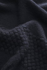 Close-up image taken from a top-down perspective showing the fabric texture of the 04651/ A trip in a bag V-Neck Pullover 'Light Wool' navy, featuring a mix of wool and microfiber, fine knit pattern, soft touch, Regular Fit, V-neck, textured knit at hem a